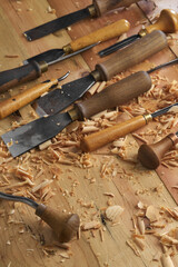 Poster - Professional tools on a wooden table in the workshop. Surface covered with sawdust. Carpenter working with tools close-up