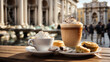 closeup of cappuccino hot chocolate and pastries on the table with the background of the trevi fountain in rome blurred