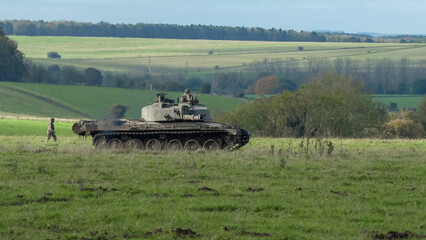 a soldier directing an FV4034 Challenger 2 II main battle tank across a field. Wilts UK