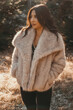 Chic winter shot featuring a beautiful woman in a fur jacket, radiating glamour and sophistication with a confident pose