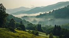 Misty Morning Light Gently Envelops Lush Green Mountains, Creating A Serene And Tranquil Landscape