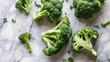 Fresh green broccoli on white marble background, top view, flat lay