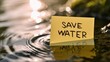 © MstAsma - The text SAVE WATER written in a sticky note, sticky note on the water