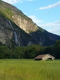Fototapeta Morze - Waterfall in the mountains, Norway. Summer landscape with wooden house in the middle of a field
