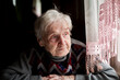 © De Visu - Portrait of an elderly woman sitting near a window.
