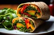Close-up shot of a colorful veggie wrap, showcasing the crispness of bell peppers, hummus, and fresh spinach.