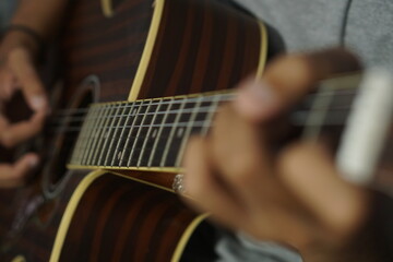 Close-up man playing acoustic guitar