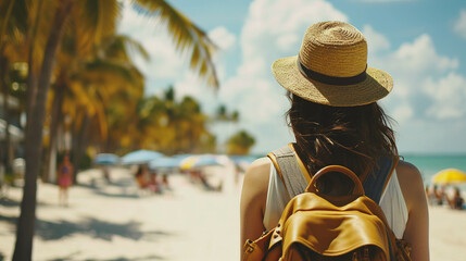 Wall Mural - Back view of Female tourist with hat and backpack at the beach and sea side. Wanderlust concept.