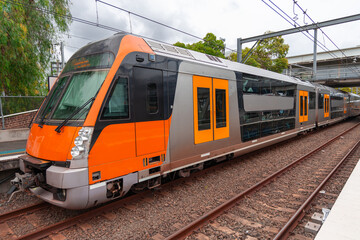 Commuter Train fast moving through a Station in Sydney NSW Australia locomotive electric light rail