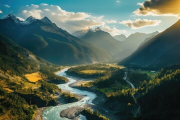 Wall Mural - Mountainous scenery with a flowing river, lush forest, and peaks, illuminated by sun and shadows.