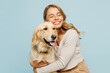 Young smiling happy cheerful owner woman with her best friend retriever wear casual clothes cuddle hug dog close eyes isolated on plain pastel light blue background studio Take care about pet concept