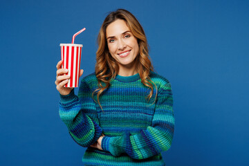 Sticker - Young smiling happy woman wear knitted sweater casual clothes hold in hands cup of soda pop cola fizzy water look camera isolated on plain blue cyan color background studio portrait Lifestyle concept