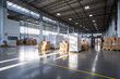 Brightly lit warehouse with pallets and reflective concrete floor