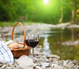 Red wine, cheese and bread served at a picnic