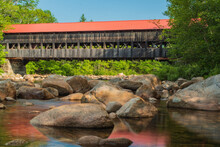 Covered Bridge With Red Roof Crosses River In The White Mountain National Park In NH, Red Roof Is Reflected In The River