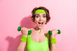 Photo portrait of pretty young girl lifting dumbbells excited coach dressed stylish green sport jumpsuit isolated on pink color background