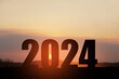 Silhouette 2024 with sunset sky at mountain and number like 2024 abstract background. Concept of start with strategy, win, plan, goal and objective target.