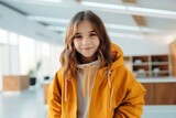 Fototapeta Sawanna - Portrait of a young woman in a yellow jacket in the office
