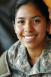 © Ema - Hispanic woman wearing army universal camouflage uniform smiling
