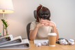 © Jo Panuwat D - Asian woman having Tired and Stressed while working, female businesswoman having headache and Migraine at office, Exhausted woman with document folder stack at home late night. Overworked and Overtime