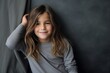 Portrait of a cute little girl with long hair on dark background