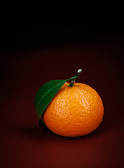 Two ripe juicy tangerines on a dark red background.