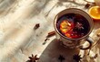 Sundrenched aromatic hot mulled wine in a mug with spices and lemon. Aerial view. Traditional hot winter drink. Top view of mulled wine with cinnamon anise and lemon in a glass on the table.