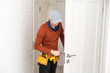 © Angelov - Young handyman installing a white door