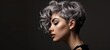© Georgii - Close-up profile portrait of a young Caucasian woman with short hair dyed grey. Attractive female model with trendy hairstyle and perfect makeup. Isolated on black background.