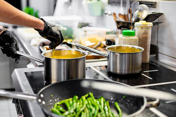 Wall Mural - Chef hands cooking cheese sauce in the restaurant kitchen