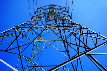 steel electricity pylon and high voltage power line electricity transmission photo with blue sky bac