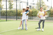 Active young woman practicing Padel Tennis with group of players in the tennis court outdoors