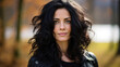 © PaulShlykov - Outdoor close-up portrait of a beautiful mature brunette woman smiling broadly and looking to camera, posing against nature background in the park. Pretty female walking in park.