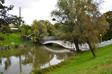 Kaliningrad, Russia, beautiful arch bridge in autumn park, city pond, cloudy day, bridge over the river