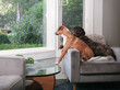 © Petra Richli - Two dogs sitting by the window watching the neighborhood, with defocused front yard. Puppy dog friends sitting together on the same chair. Female Labradoodle and female Harrier mix. Selective focus.
