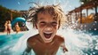 Child emotionally rejoices and laughs while swimming in a water park in summer in sunny weather. The joy of a child relaxing in a water park in summer.