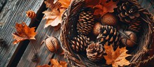 Set Of Pine Cones And Holm Oak Leaves In An Esparto Basket Next To A Yellow Pumpkin On A Wooden Table Seen From A Zenithal View. Creative Banner. Copyspace Image