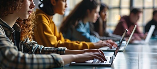 University students sitting together at table using laptop in class Young people working on laptop in library. Creative Banner. Copyspace image