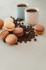 Coffee beans, chocolate macaron, French macaroon and two coffee cups, a romantic breakfast on Valentine's Day. Weight problems, excess sugar and calories, unhealthy diet. French traditional cookies