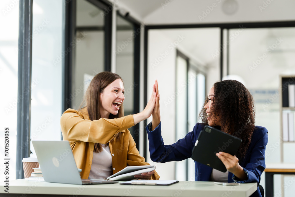 Caucasian and an African American university woman giving a high-five ...