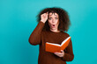 © deagreez - Photo of surprised funky young woman student hold book amazed reading novel romantic story isolated on aquamarine color background