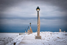 Lake Erie Pier In  Ontario, Canada,  Light Posts Covered In Ice. Natural Made Ice Sculptures Created From Waves During A Winter Storm