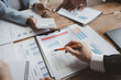 © kamiphotos - Team of analyst working on financial data analysis dashboard on paper as marketing indication for business strategic planning, Insight, They are calculating the taxes they have to pay,