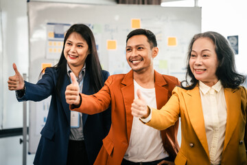 Wall Mural - Asian business professionals team actively engaged in collaborative meeting in boardroom, sharing opinions and working together with visible happiness.