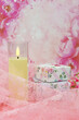 Candle and boxes for decorations on a pink background. Poster for interior. Colorful boxes and a candle are surrounded by lace. There is space for text.