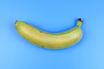Wall Mural - Whole yellow banana isolated on a blue background