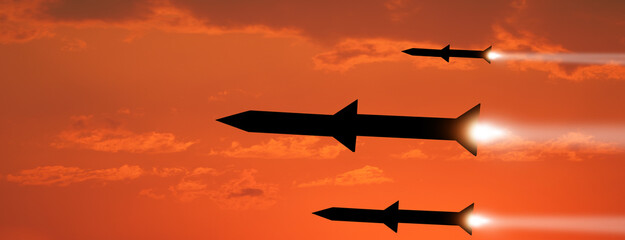 Wall Mural - Fired missiles fly to the target. Missiles at the sky at sunset. Missile defense. Rockets attack concept.