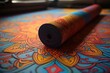 A vibrant, rolled-up yoga mat with intricate patterns