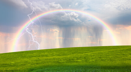 Wall Mural - lightning strikes between stormy clouds with green grass field and rainbow