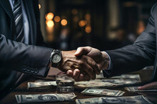 Two People Shaking Hands Over A Pile Of Money In The Background.